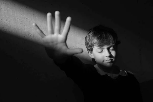 Чёрно-белый портрет мальчика в жёстком свете с глубокими тенями,